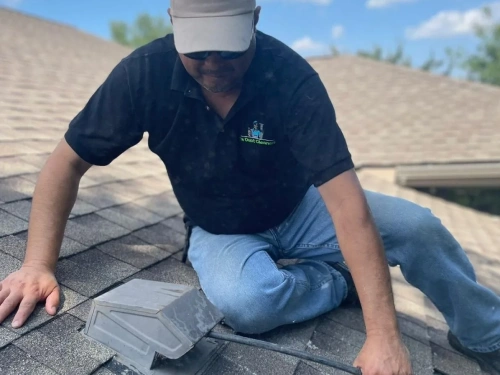 Our technician cleaning a dryer vent opening on the roof.