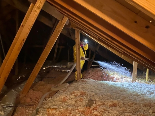 Our Technician installing insulation in the attic