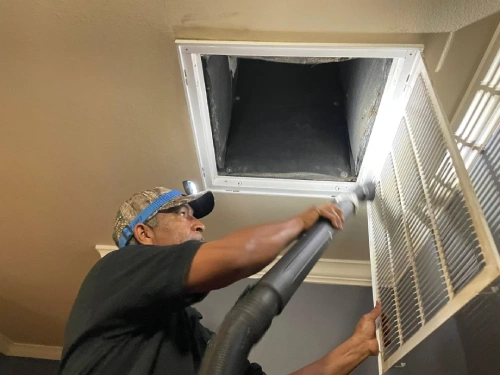 Technician cleaning HVAC Vent