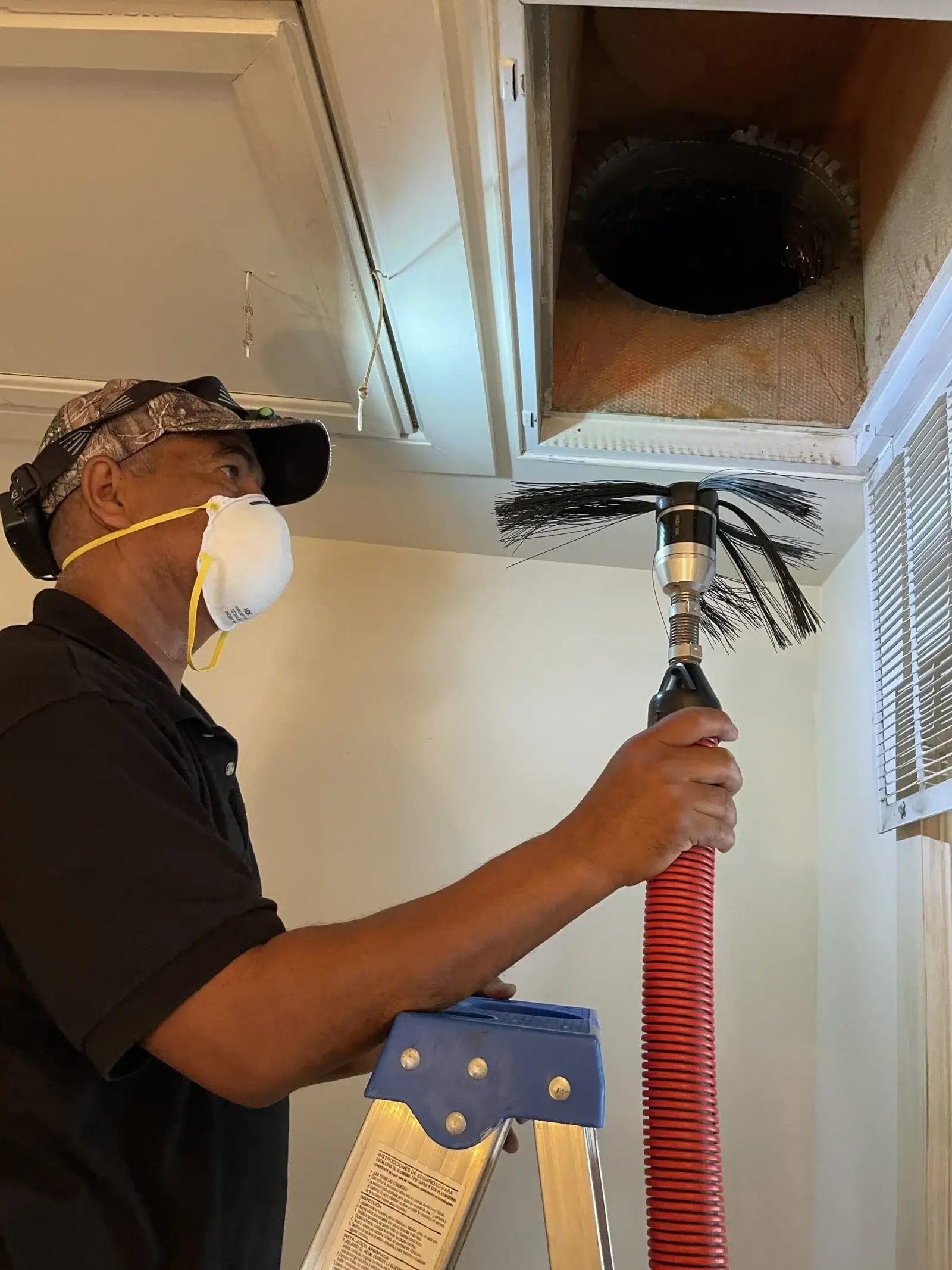 The duct cleaners technician cleaning the air duct using rotobrush