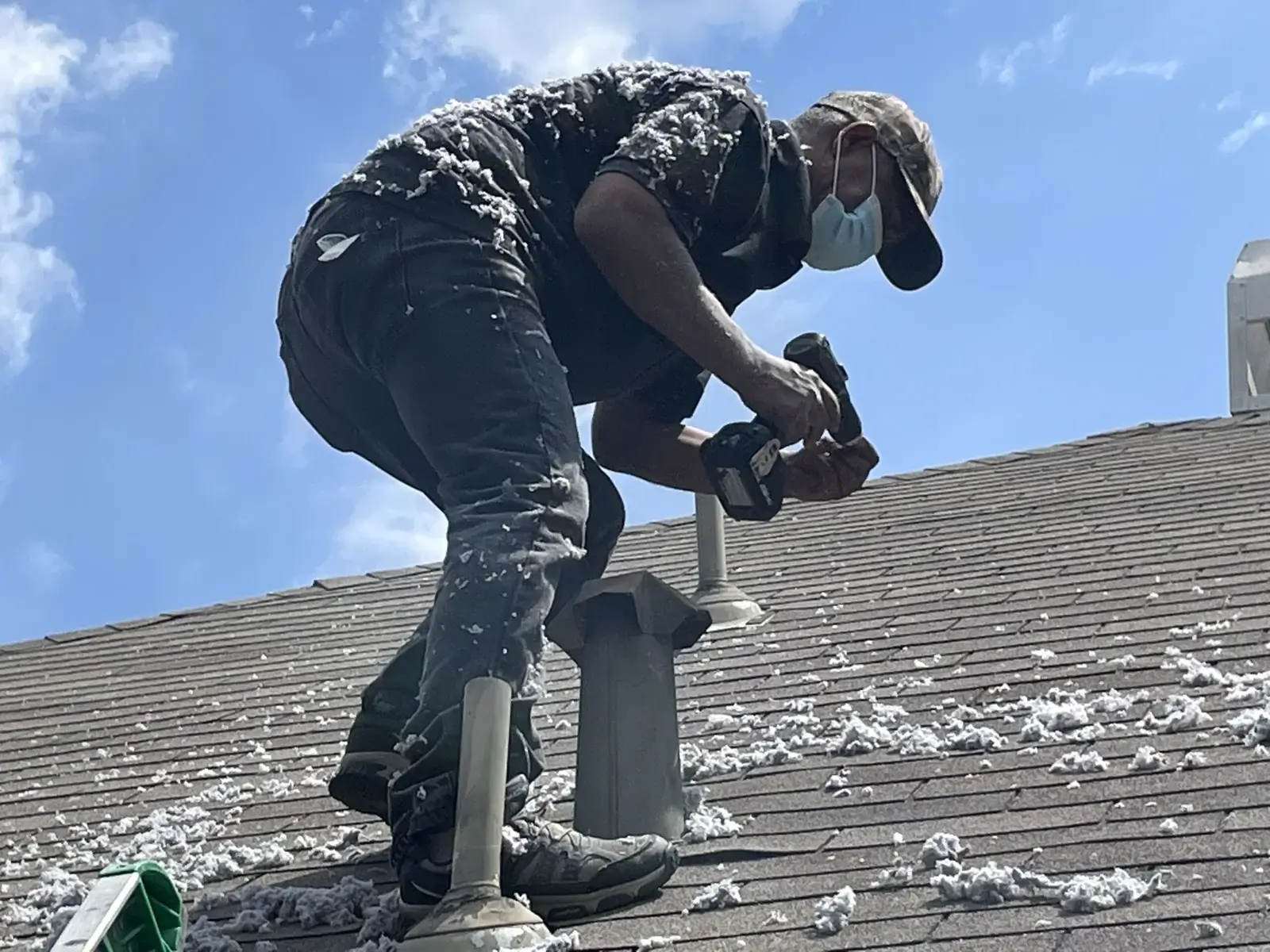 Technician cleaning dryer vent on the roof
