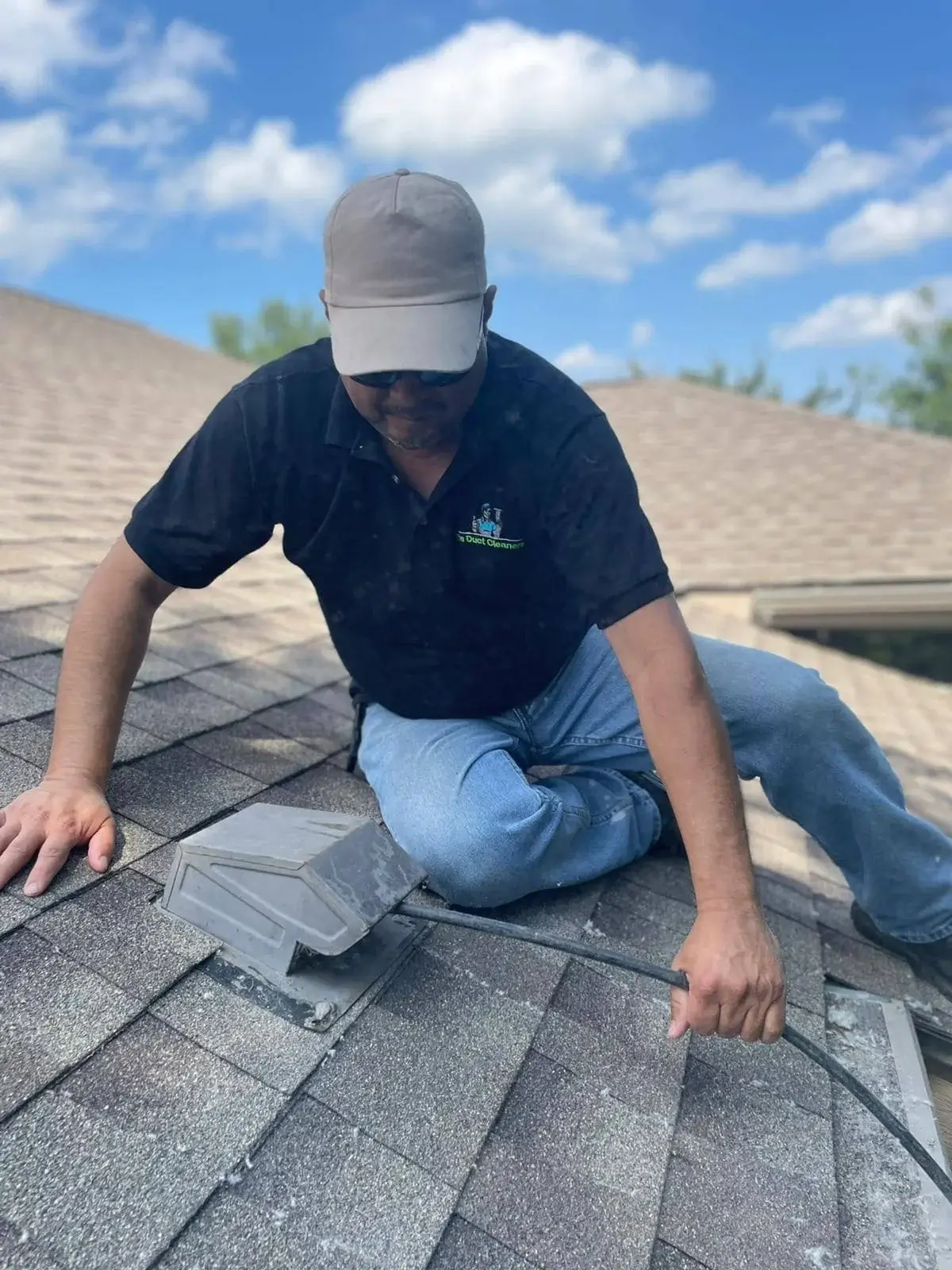 Technician cleaning dryer vent opening on the roof