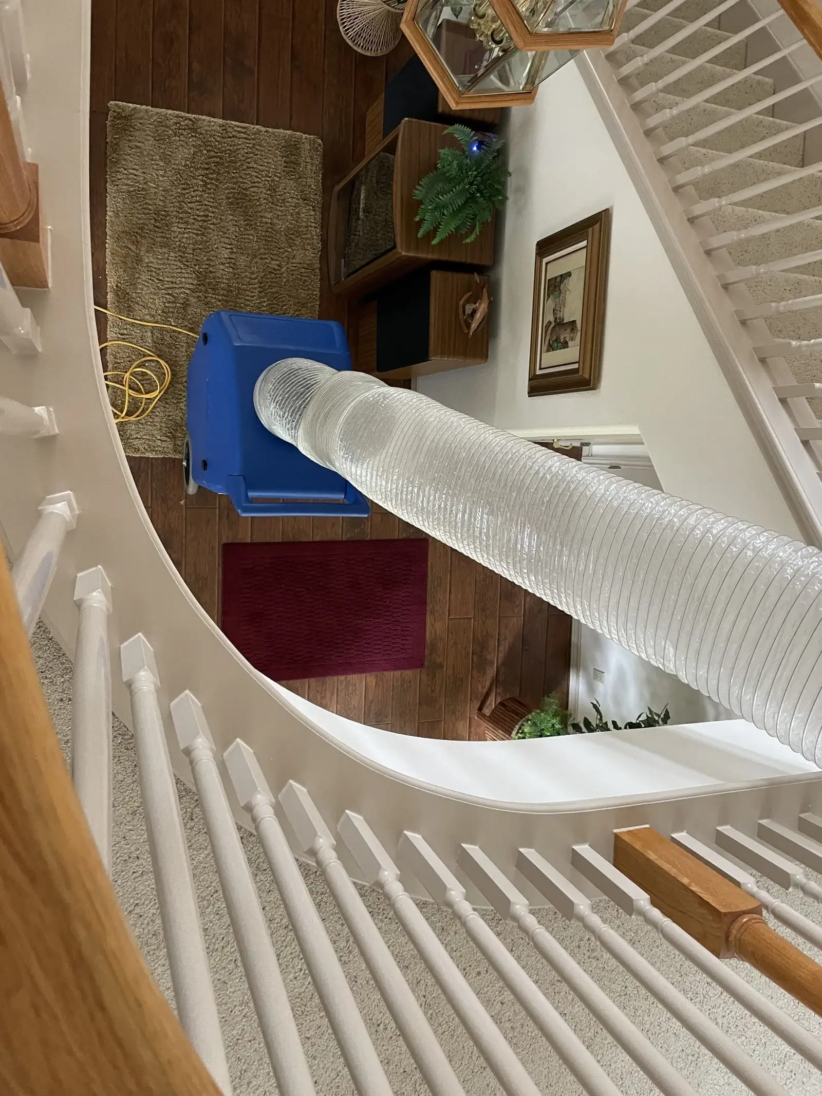 Negative air machine attached to the ceiling in the hall of a residential house