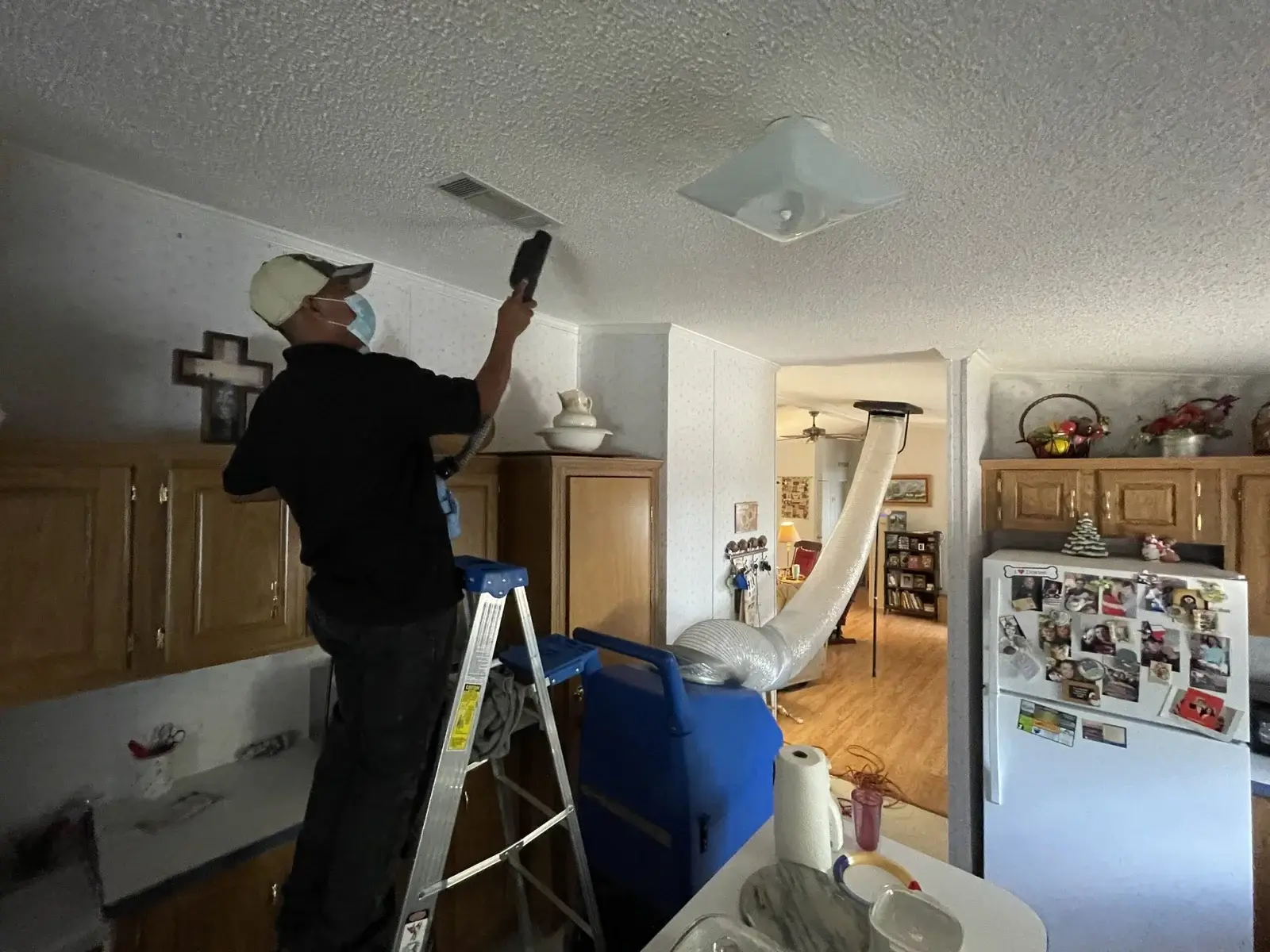 Technician cleaning air duct using handheld vacuum machine.